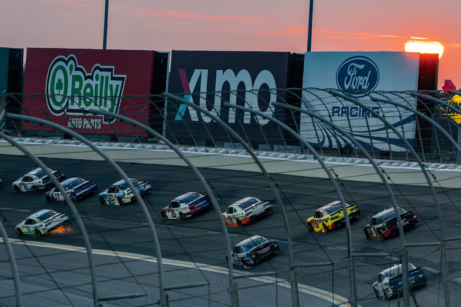 NASCAR vehicles compete on banked turn during the Bennet Transportation & Logistics 250 on February 21st 2026 at sunset