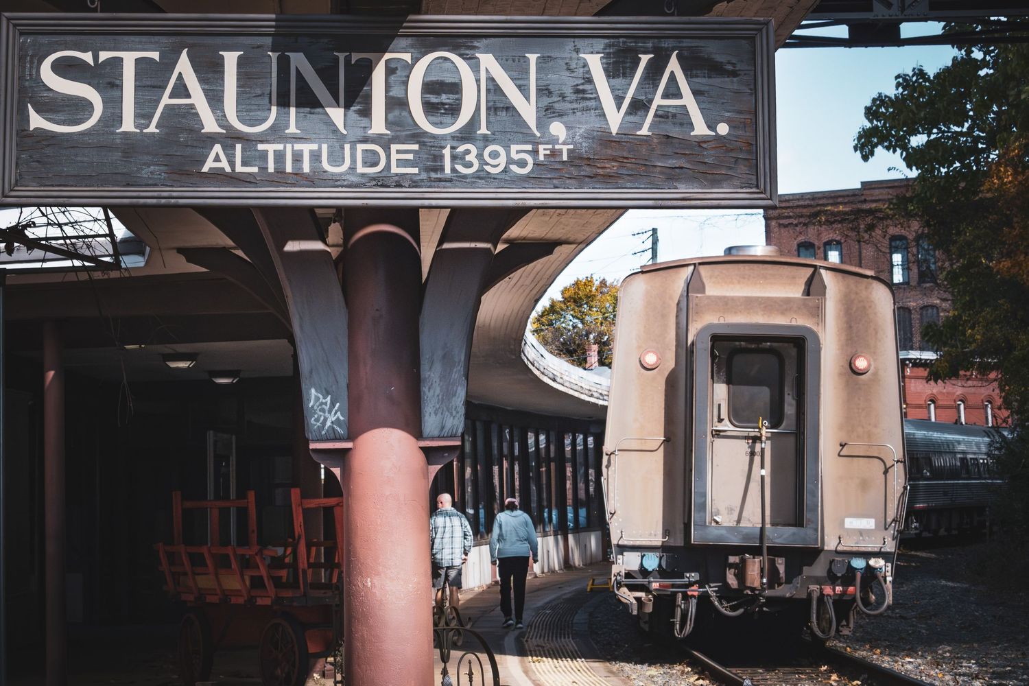 Train station platform in Staunton VA with vintage rail car and altitude marker.