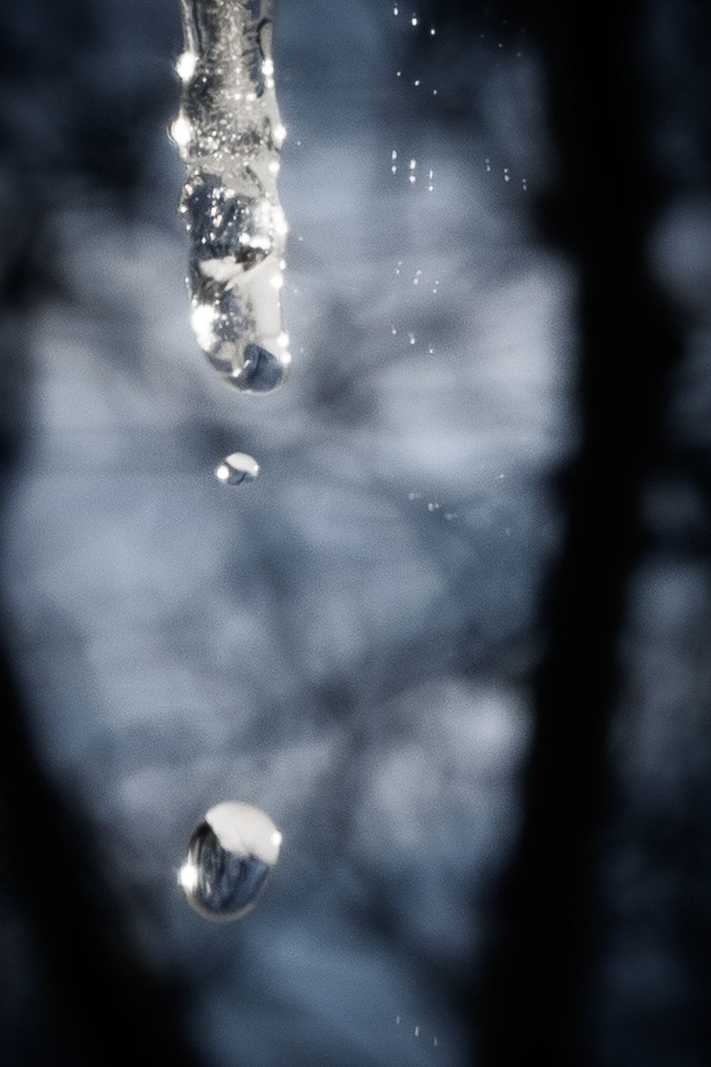 Close-up of ice crystals melting with water droplets against a misty background.