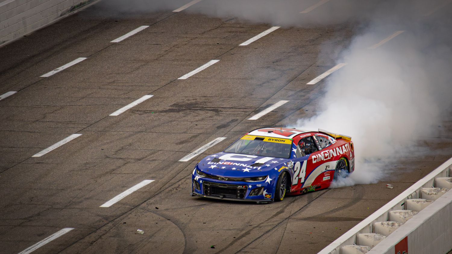 NASCAR race car spins out and hits the wall during competition.