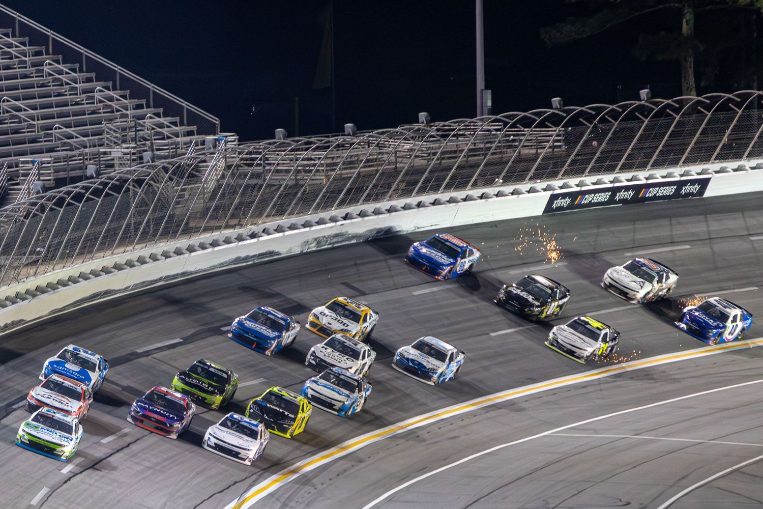 Multiple NASCAR race cars compete under the lights during the Bennet Transportation & Logistics 250 on February 21st 2026