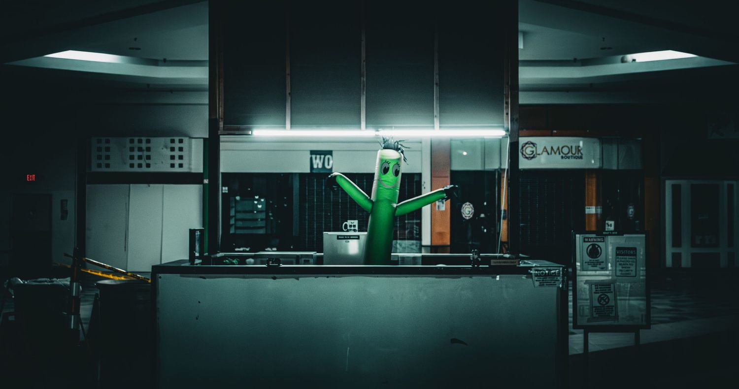 Dark interior space with minimal lighting and glowing displays creating a moody atmosphere.