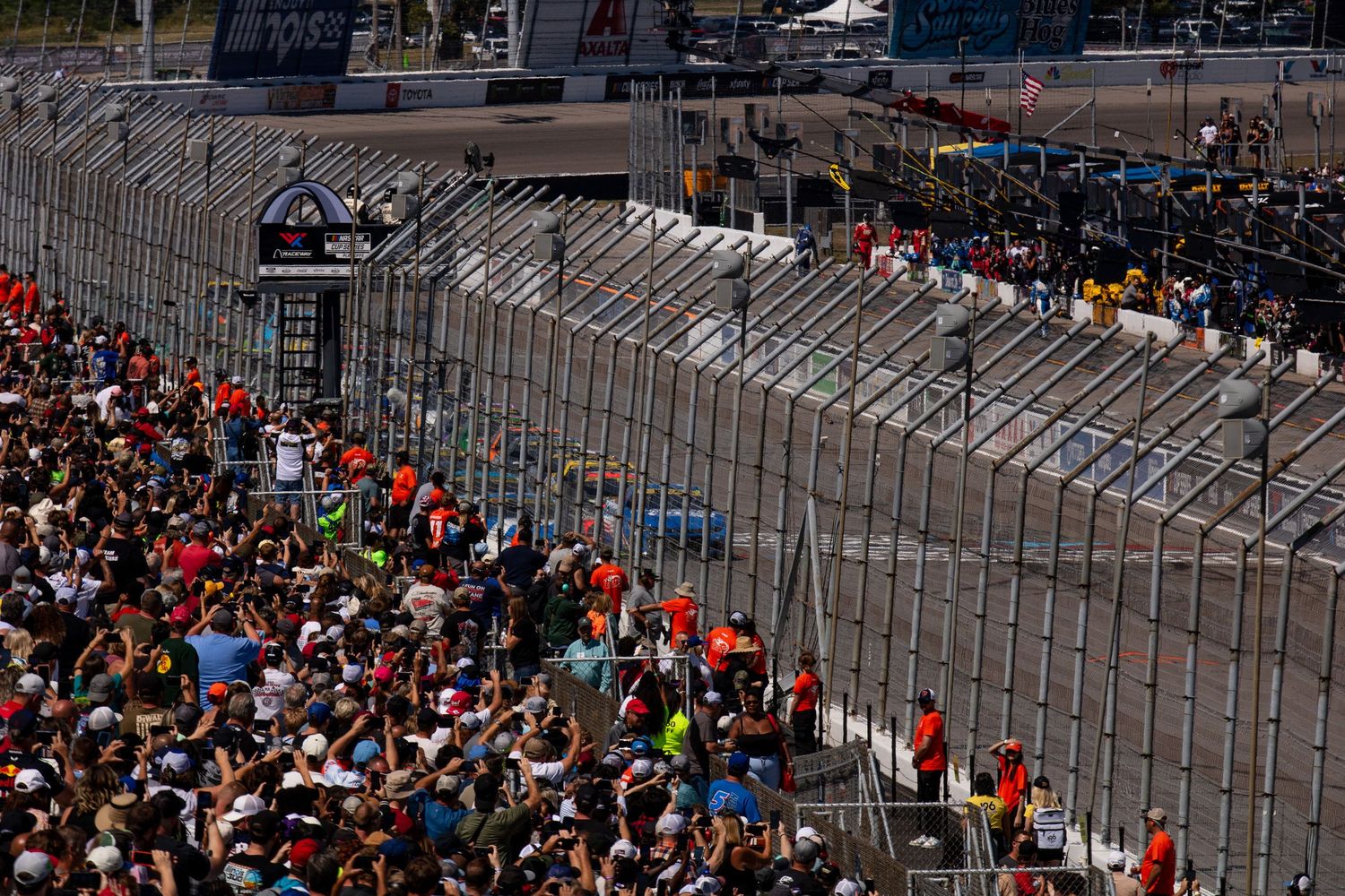 Crowded grandstands and racing barriers at a NASCAR track during race day.