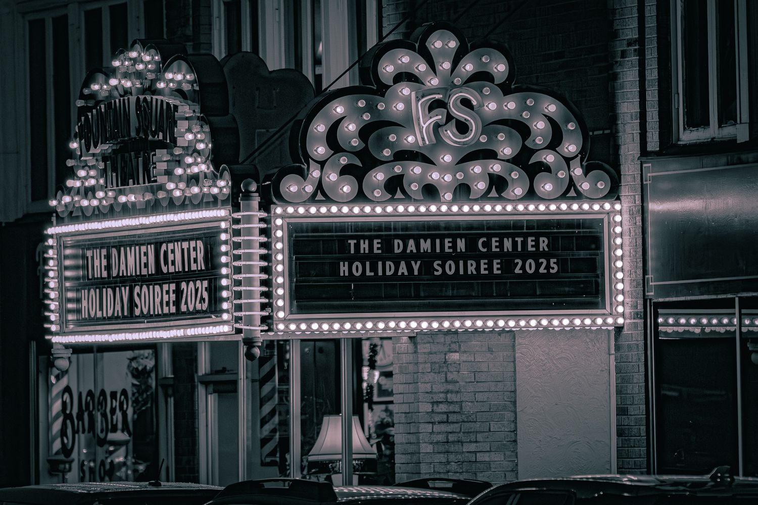 Vintage illuminated marquee signs for The Damien Center and Holiday Shows in black and white.