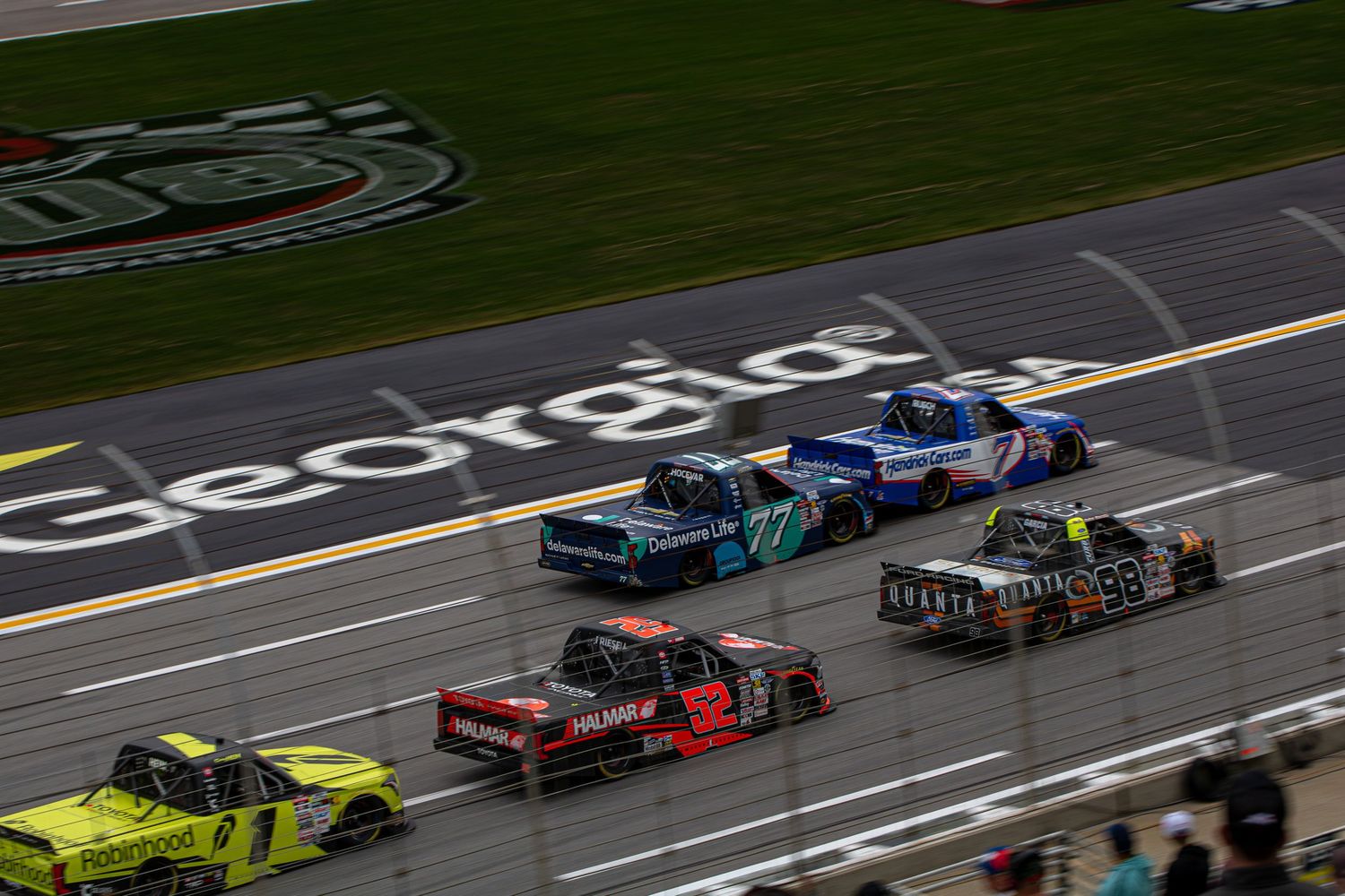 NASCAR trucks race multiple wide down the frontstretch during the Fr8 Racing 208 at EchoPark Speedway on February 21st 2026.