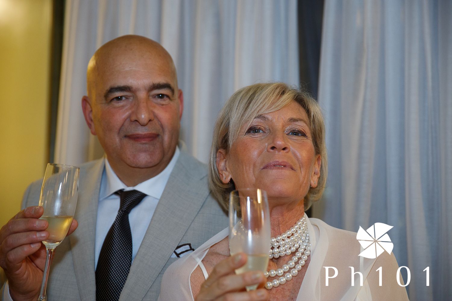 Couple celebrating with champagne glasses at an elegant event.