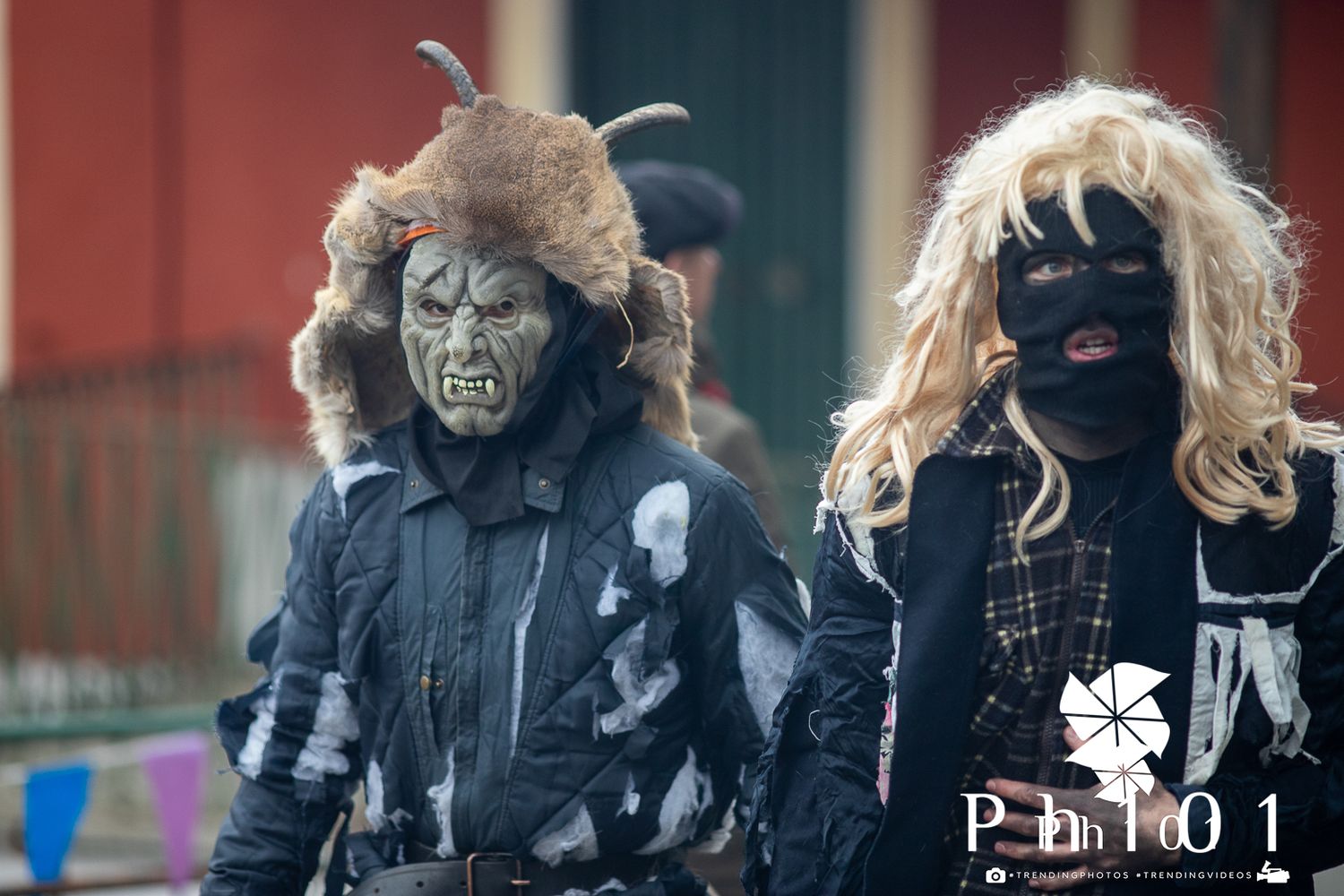 A group of performers in dark winter coats stand together outdoors.