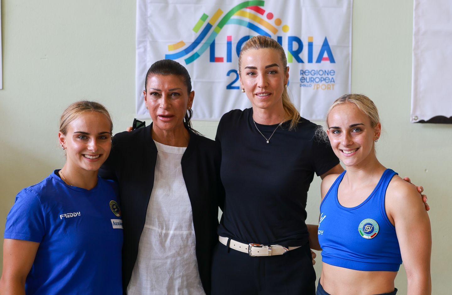 Athletes in blue and white sportswear posing together at a sports event.