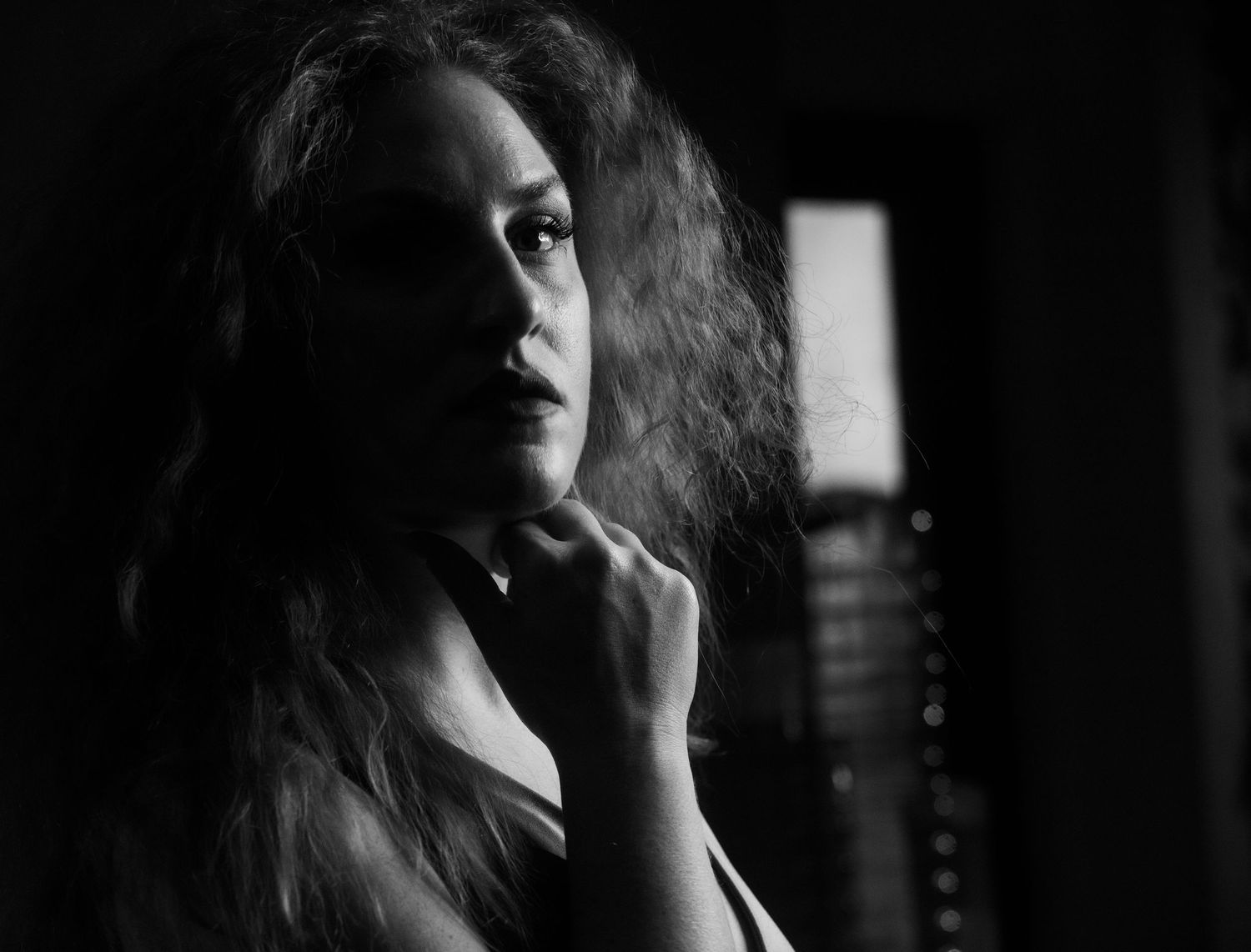 Moody black and white portrait series with dramatic shadows and lighting effects.