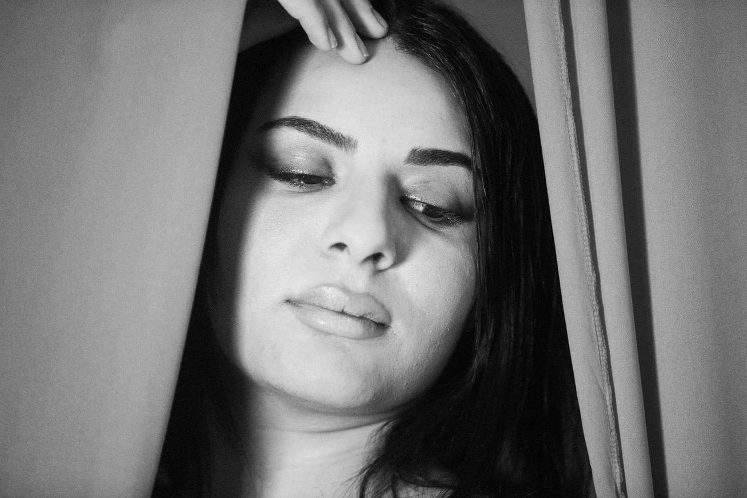 Artistic black and white portrait with soft lighting and contemplative expression.