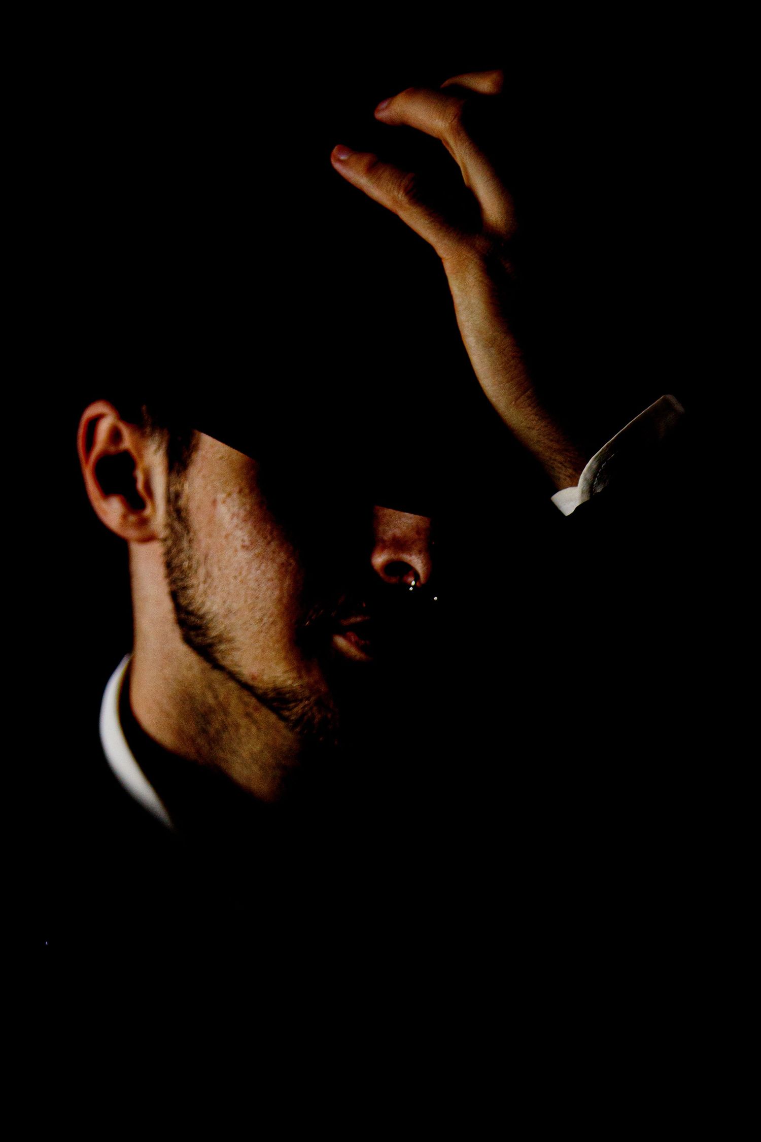 Moody low-key portraits with dramatic shadows and minimal lighting.