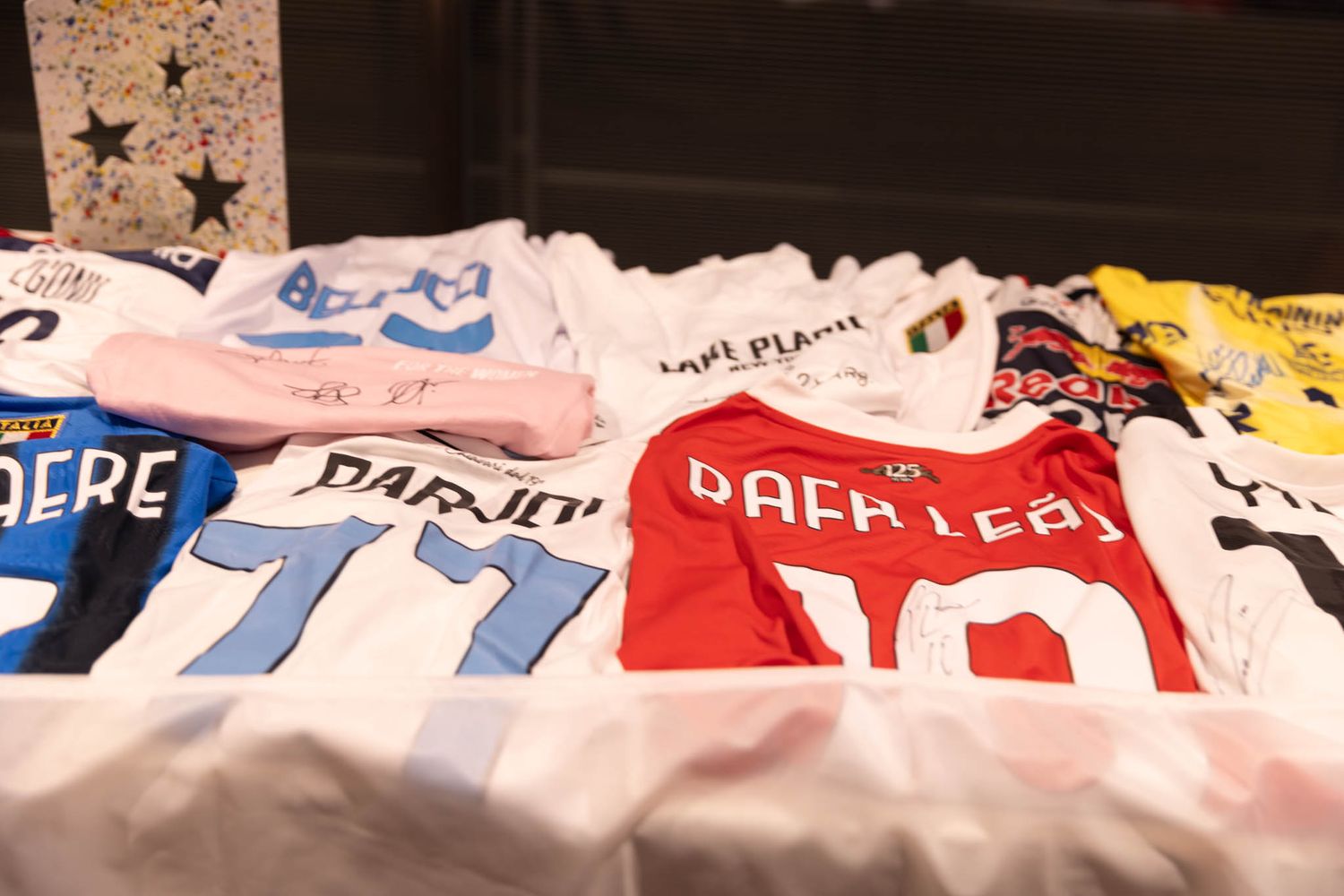 Collection of sports jerseys laid out on display at ceremonial event.