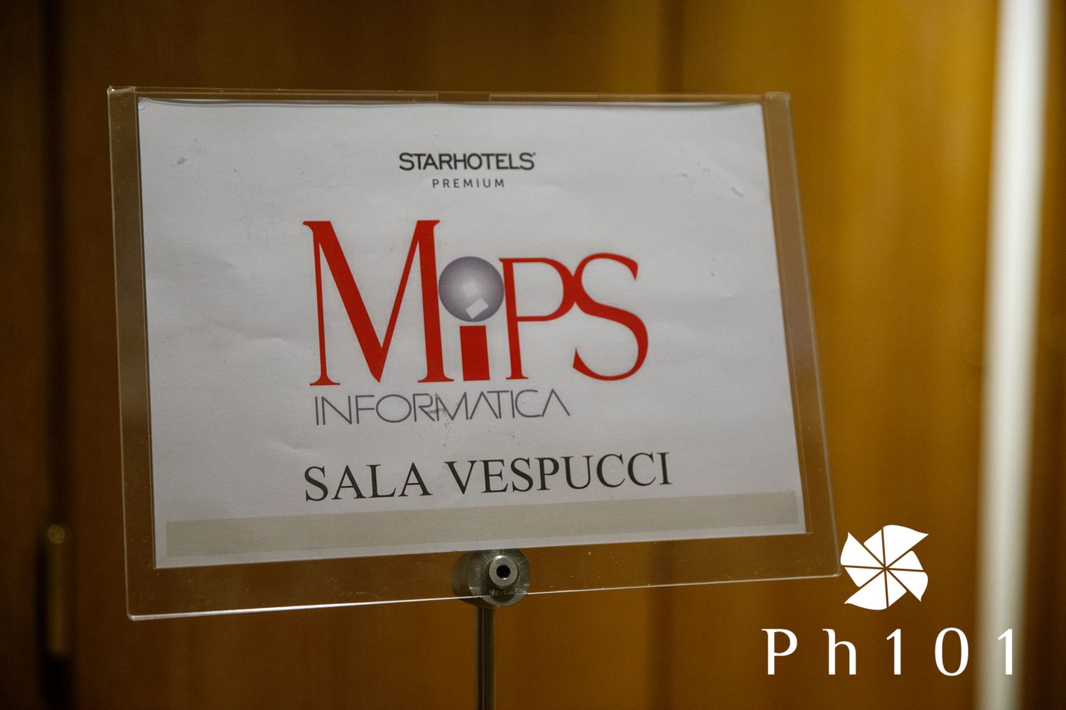 Close-up of a clear acrylic sign reading MiPS Informatica Sala Vespucci.