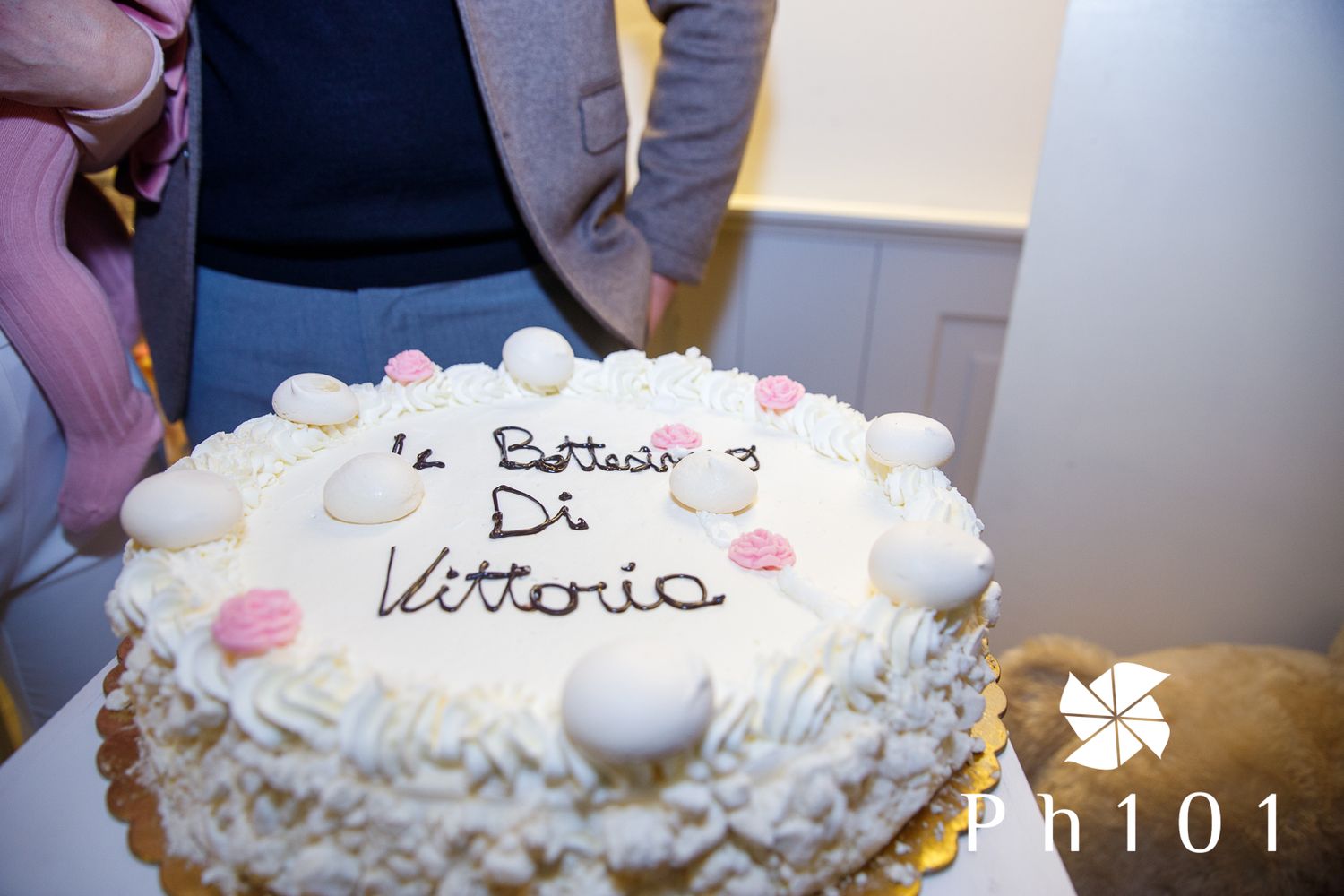 White frosted celebration cake with decorative writing on top.