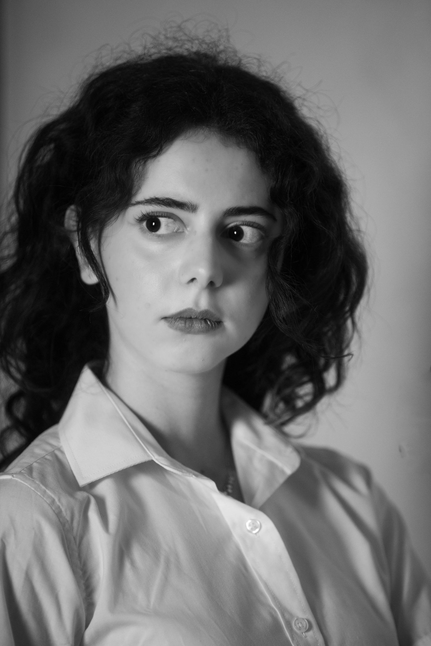 Black and white portrait series showing curly hair and white shirt against dark background.