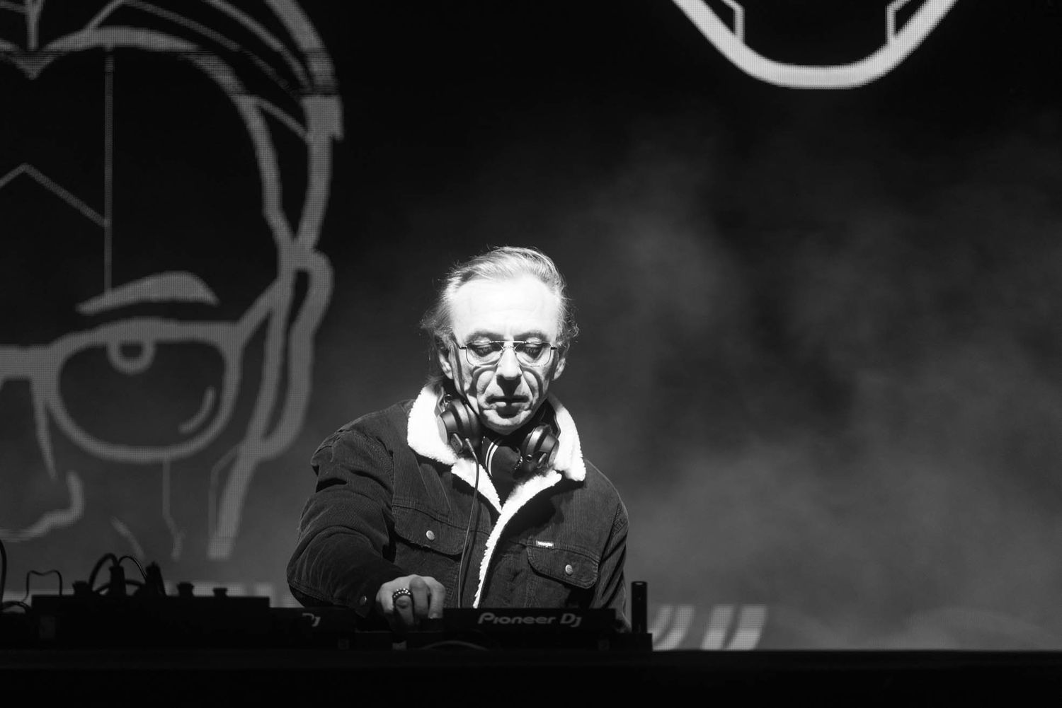 Black and white performance photo with dramatic lighting and fog effects.