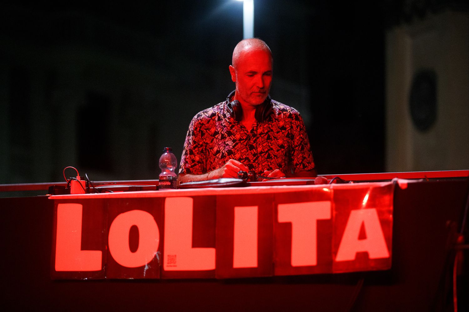 Red illuminated text sign reading 'LOLITA' mounted above a stage.