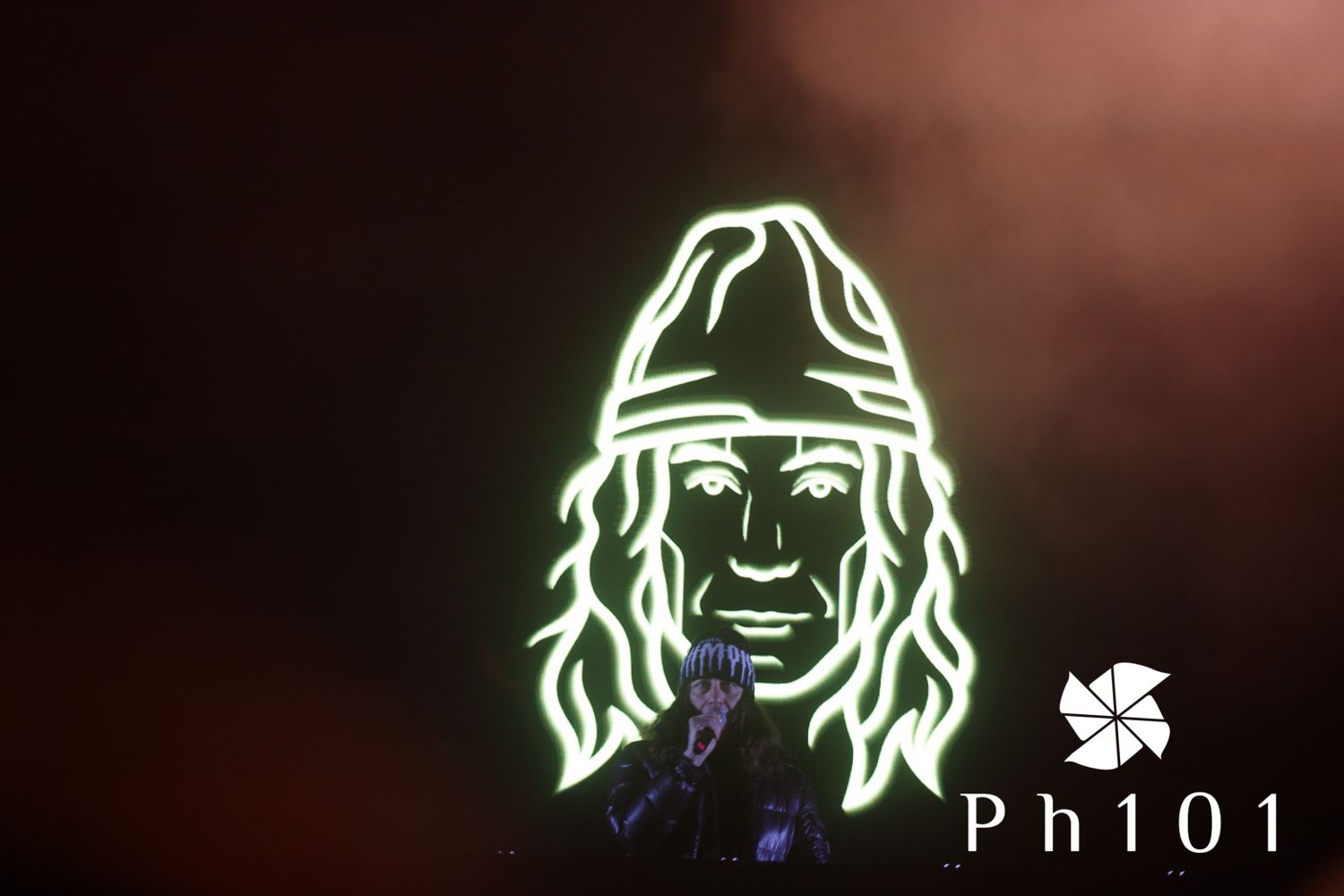 Glowing green neon outline art against dark reddish background.