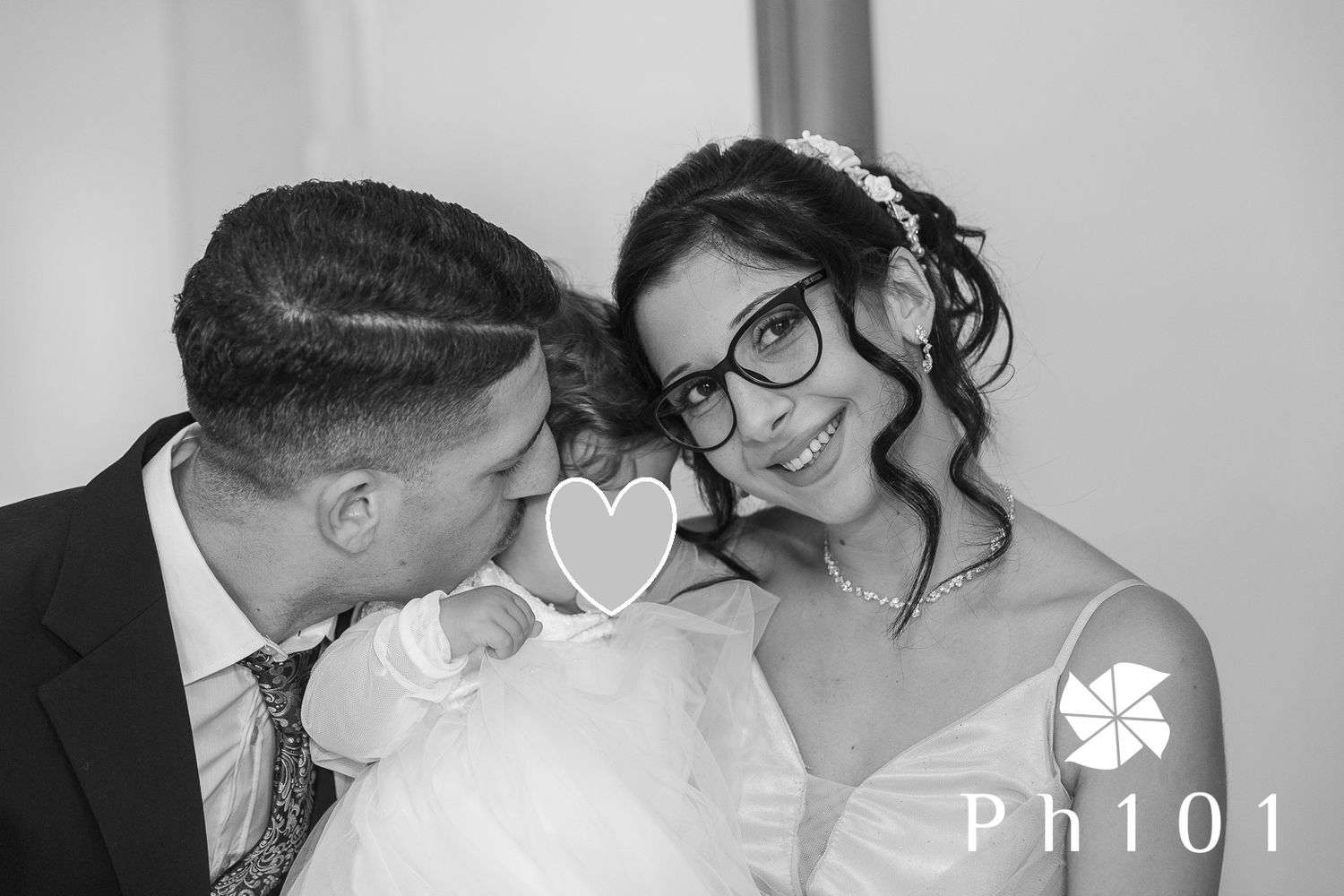 Intimate black and white portrait of a couple with their newborn baby between them.