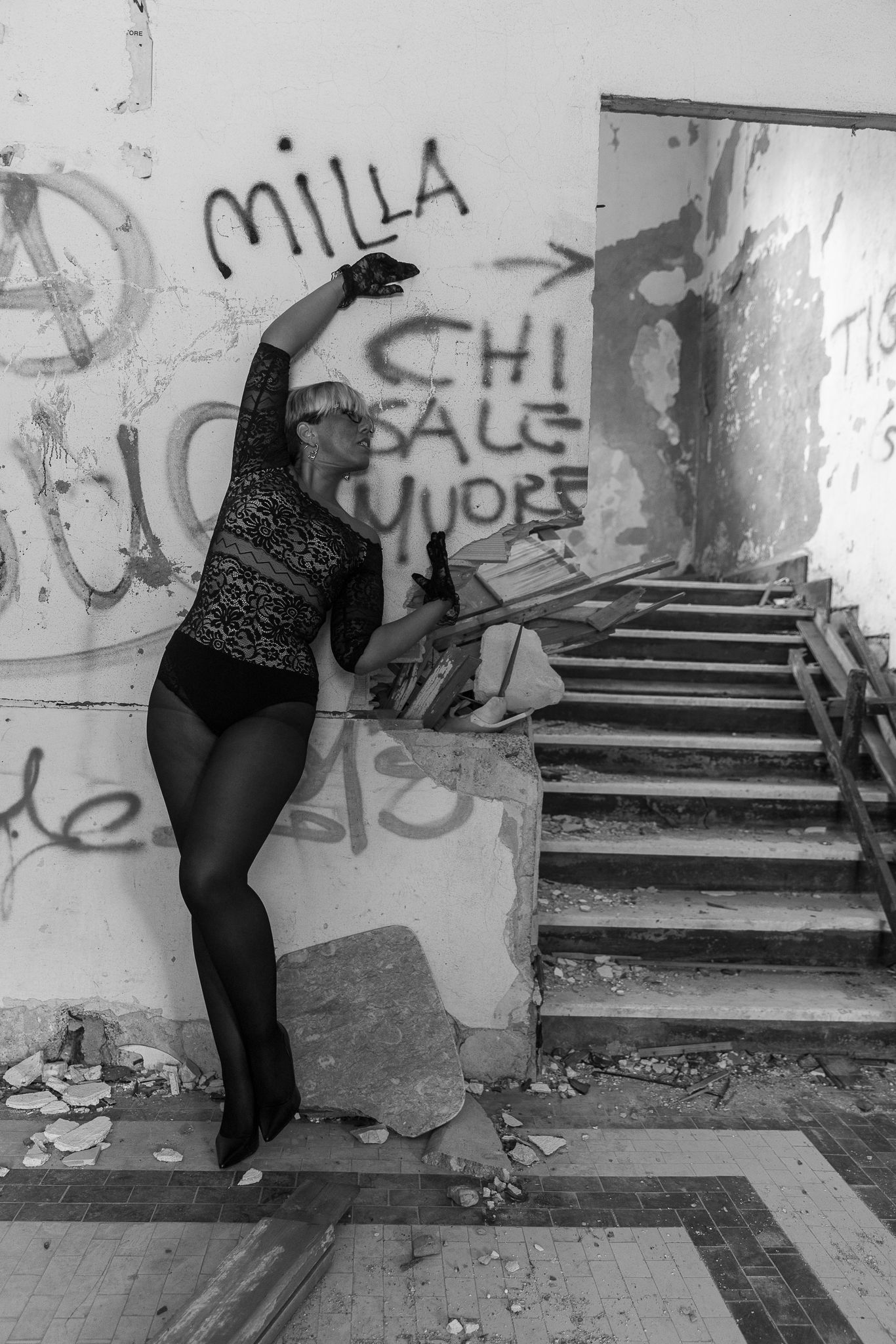 Black and white photo of graffiti covered stairwell with artistic silhouette.