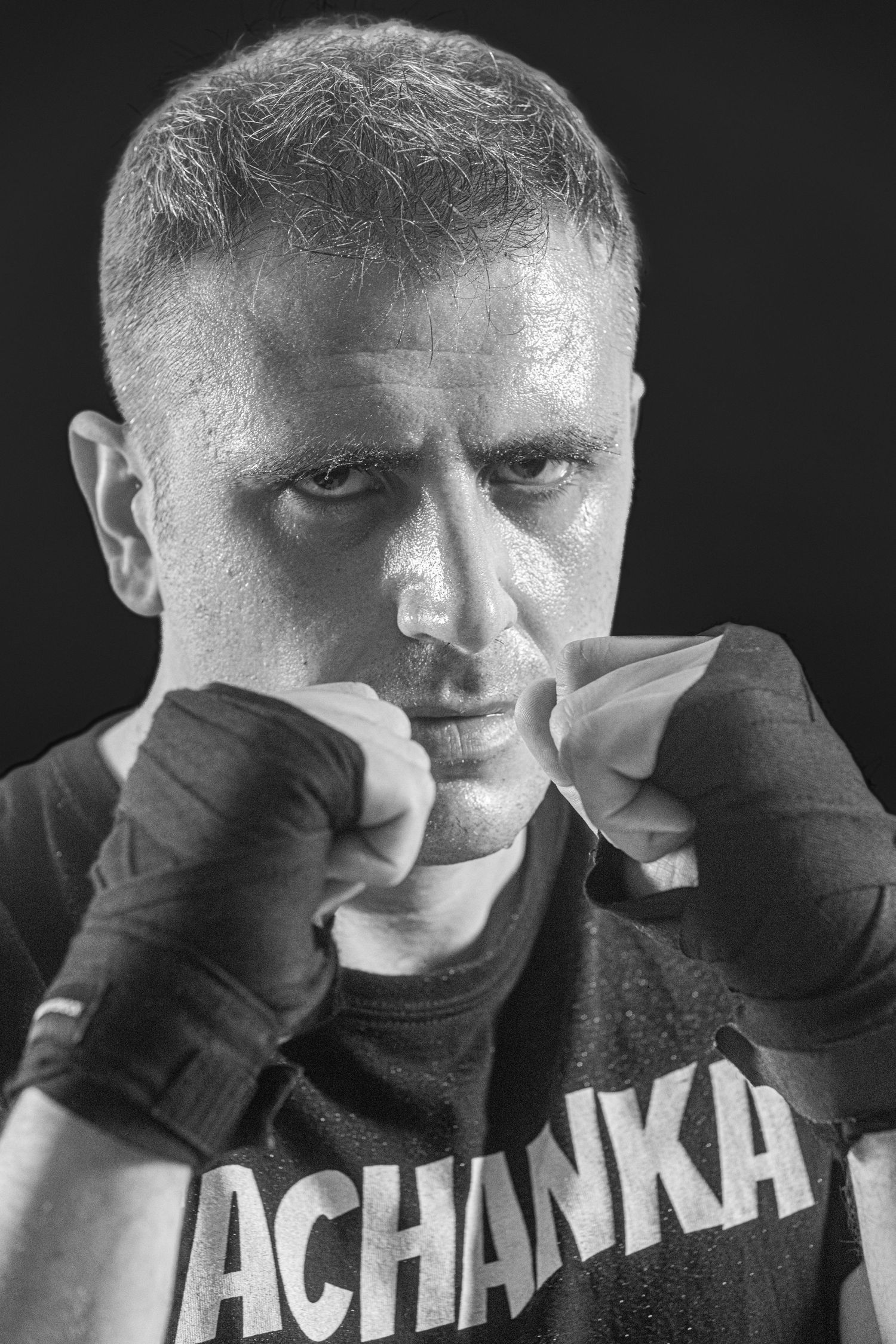 A black and white photo series showing someone in a dark shirt covering their face with their hands.