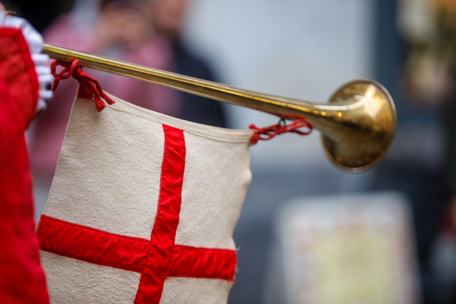 English flags with red cross design and golden trumpets displayed in sequence.