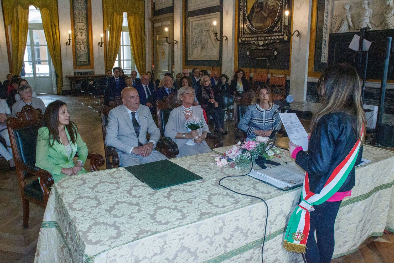 Official ceremony taking place in an ornate room with decorative tables and chairs.