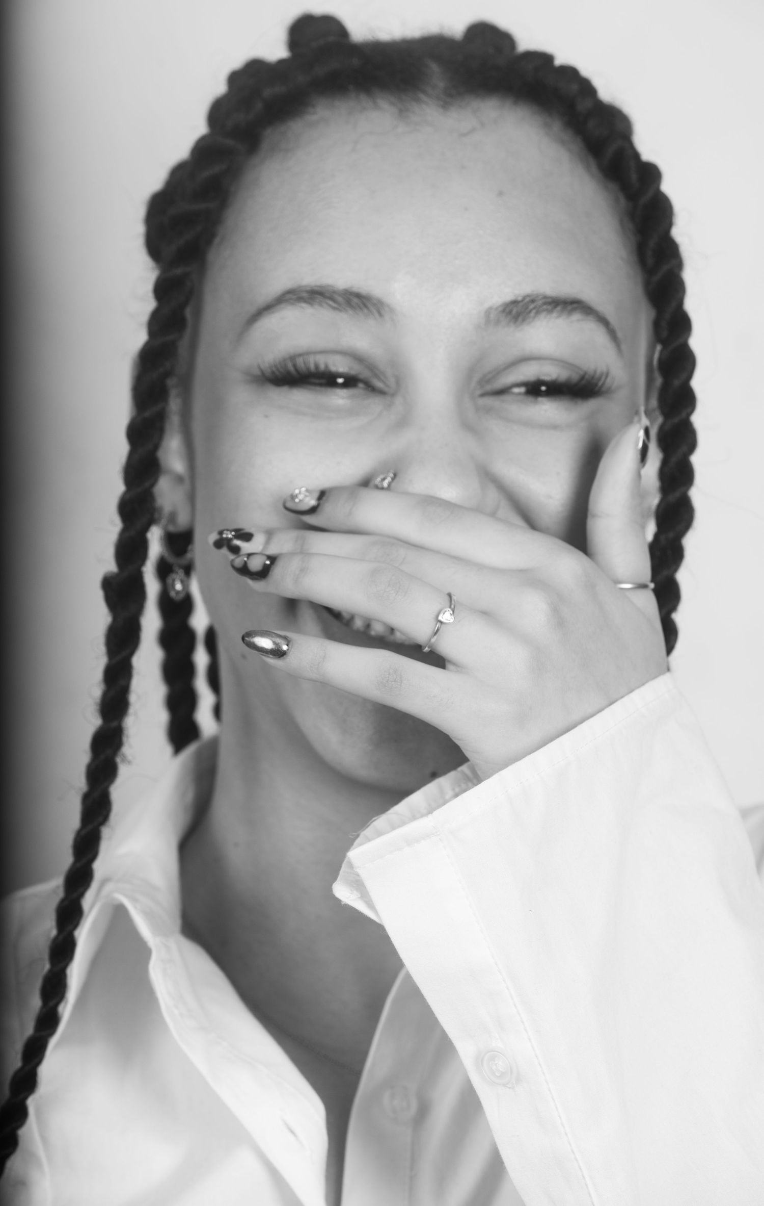Black and white portrait showing joyful expression and decorated nails.