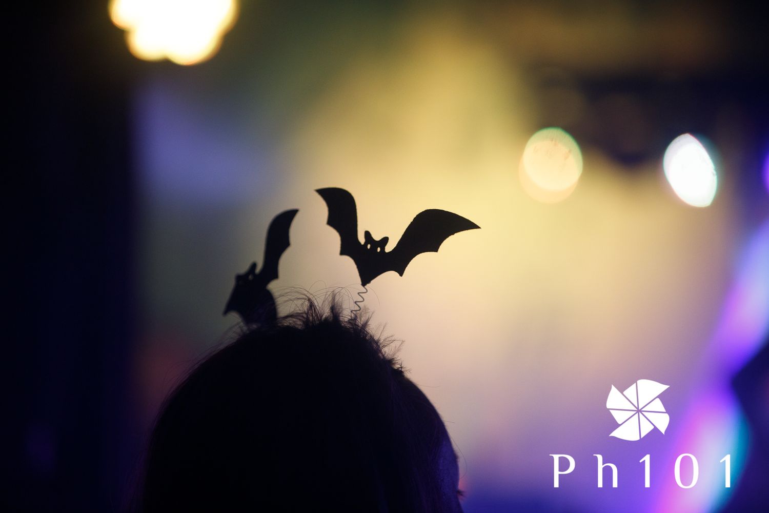 Decorative bat silhouettes against warm stage lighting during a theatrical performance.