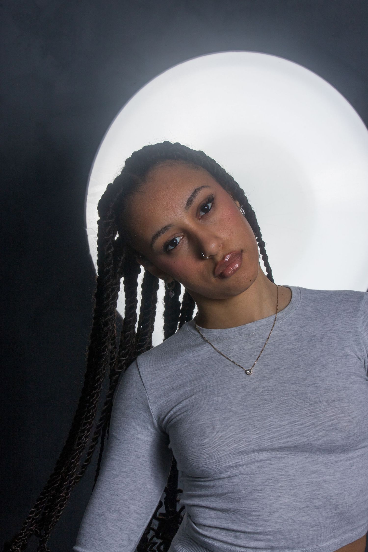 Portrait series against white backdrop showing different poses in casual grey attire.