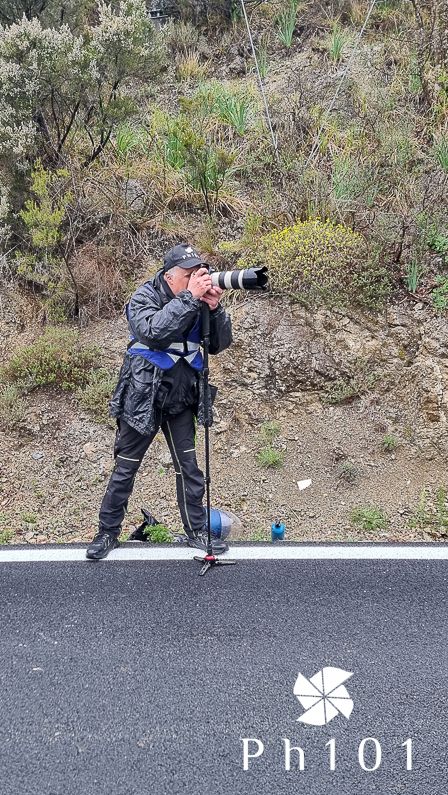Photographer lying on ground to capture creative angle shot on asphalt road.