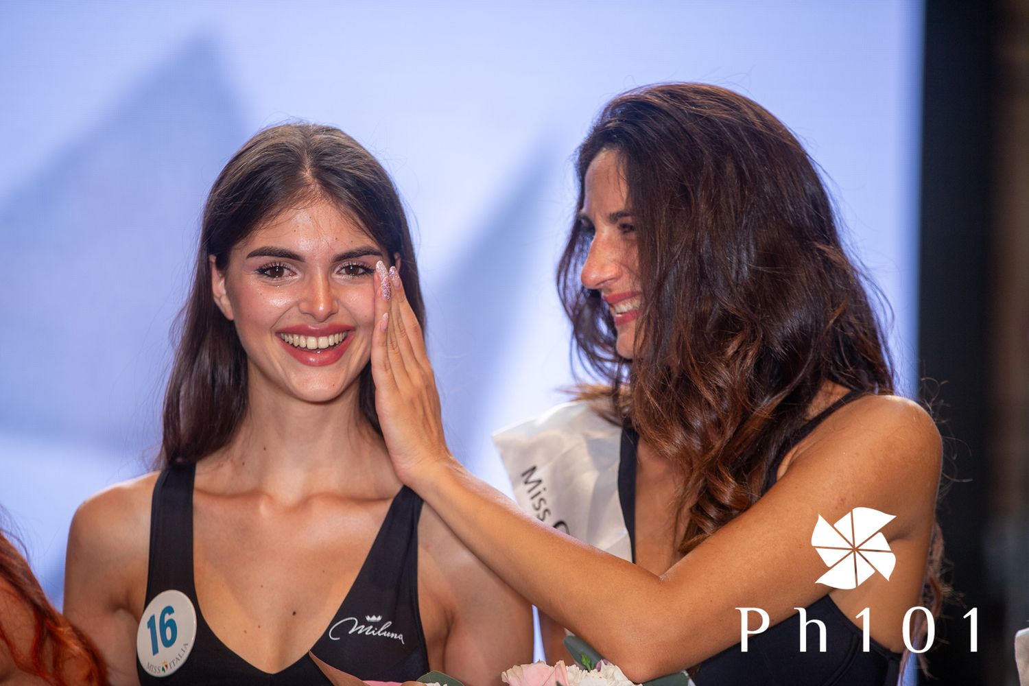 Contestants sharing joyful moments during a beauty pageant performance.