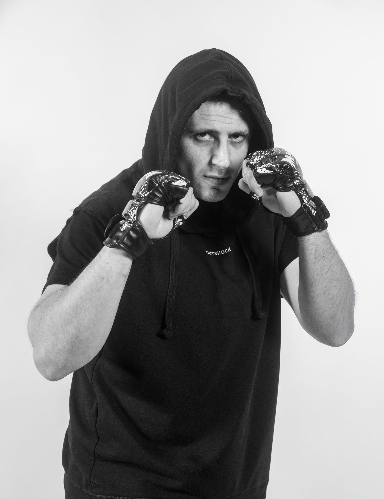 A sequence of four black and white photos showing a person in a black hoodie demonstrating boxing stances and poses.