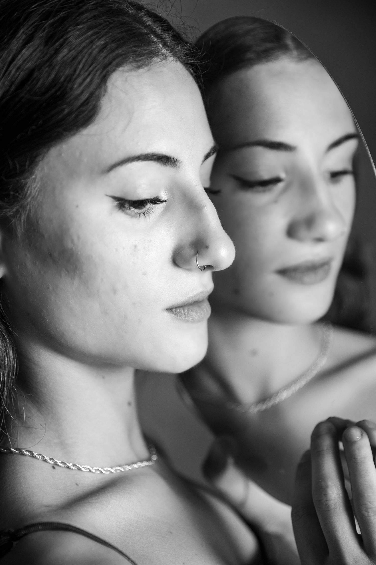 Black and white close-up portraits showing delicate facial features in dramatic lighting.