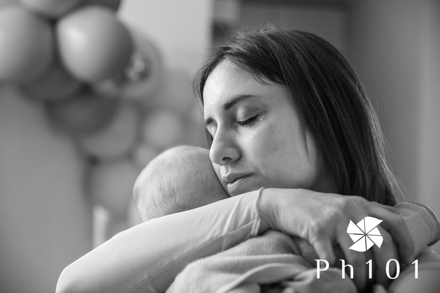 Peaceful black and white image showing a tender embrace between parent and infant.