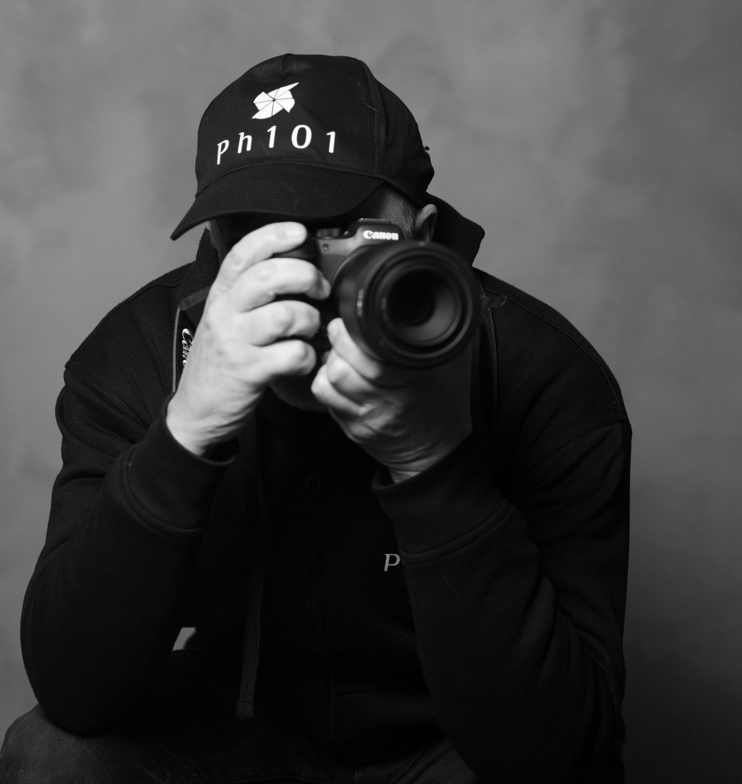 Series of black and white shots showing photographer with camera equipment in dark clothing.