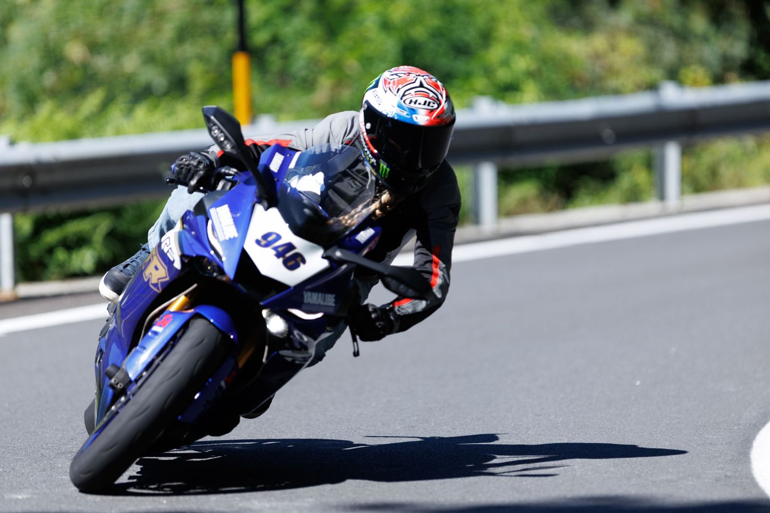 Motorcycles racing at high speed on a curving racetrack.