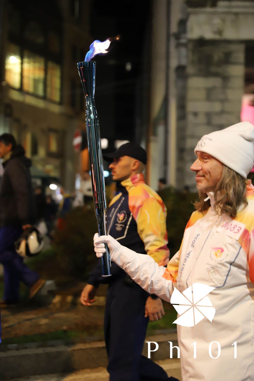 Group of winter sports enthusiasts holding equipment at night.