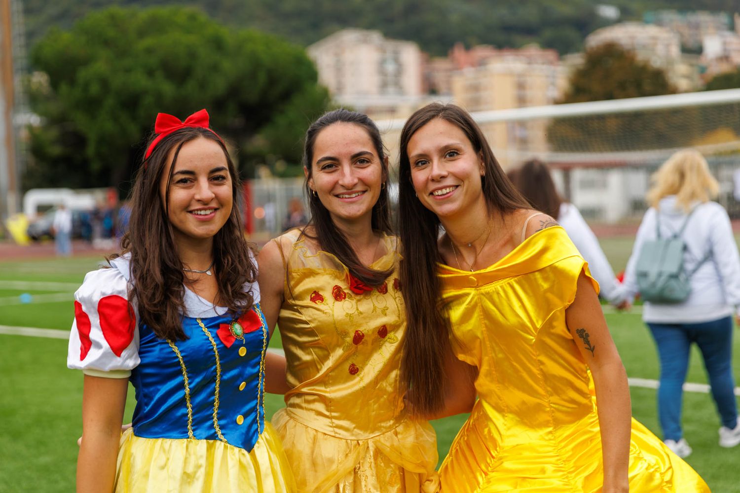 Group wearing coordinated yellow and blue outfits posing together outdoors.