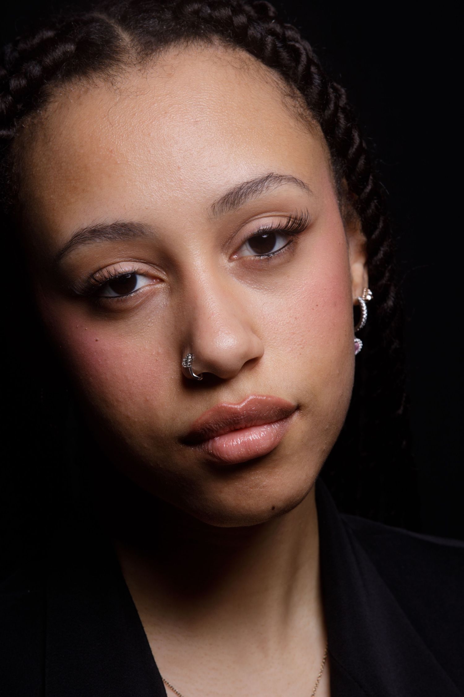 Artistic beauty portraits showing soft lighting and makeup details against black background.