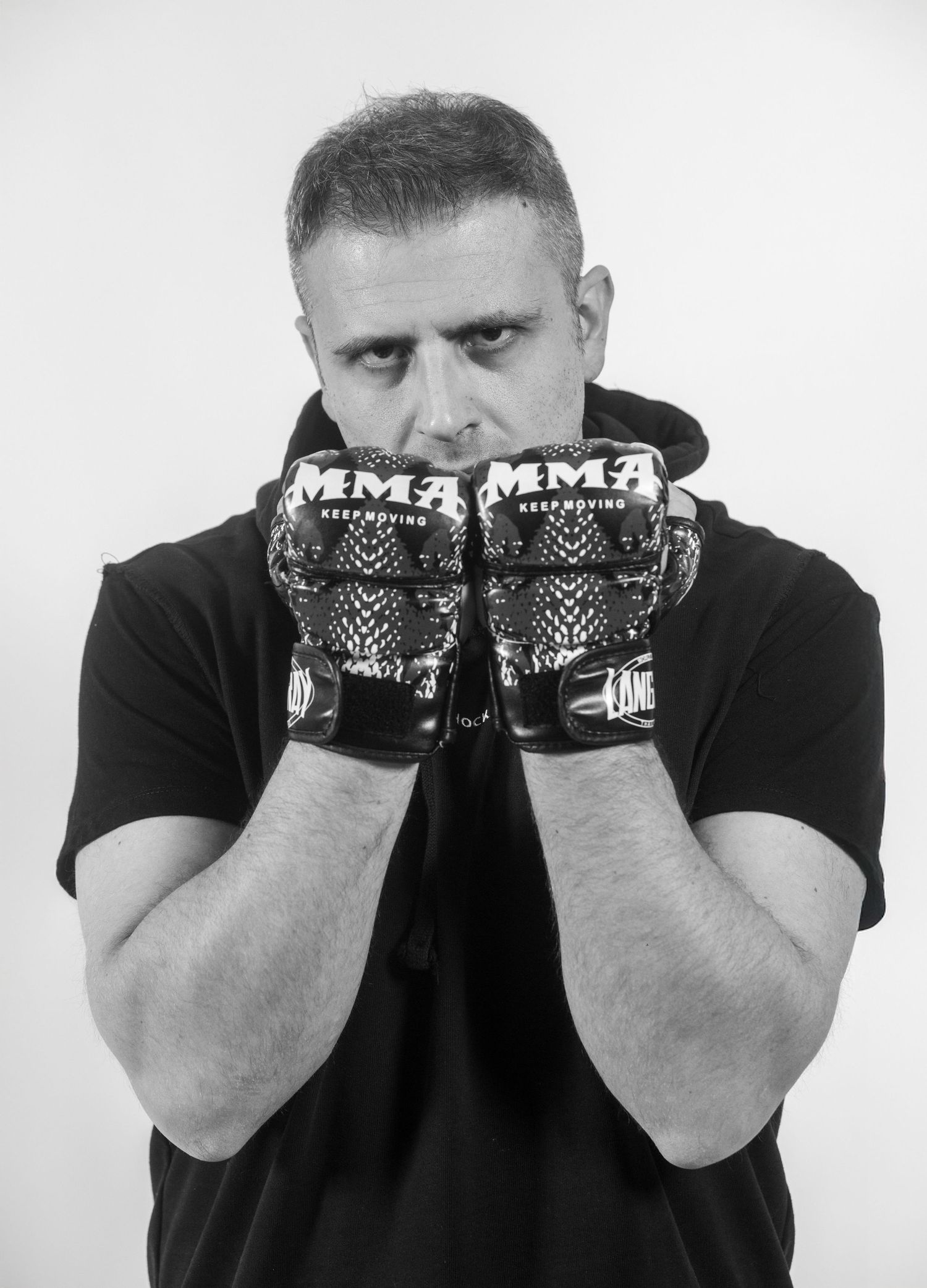 Black and white photo sequence showing a person in dark clothing covering their face with MMA gloves in different poses.