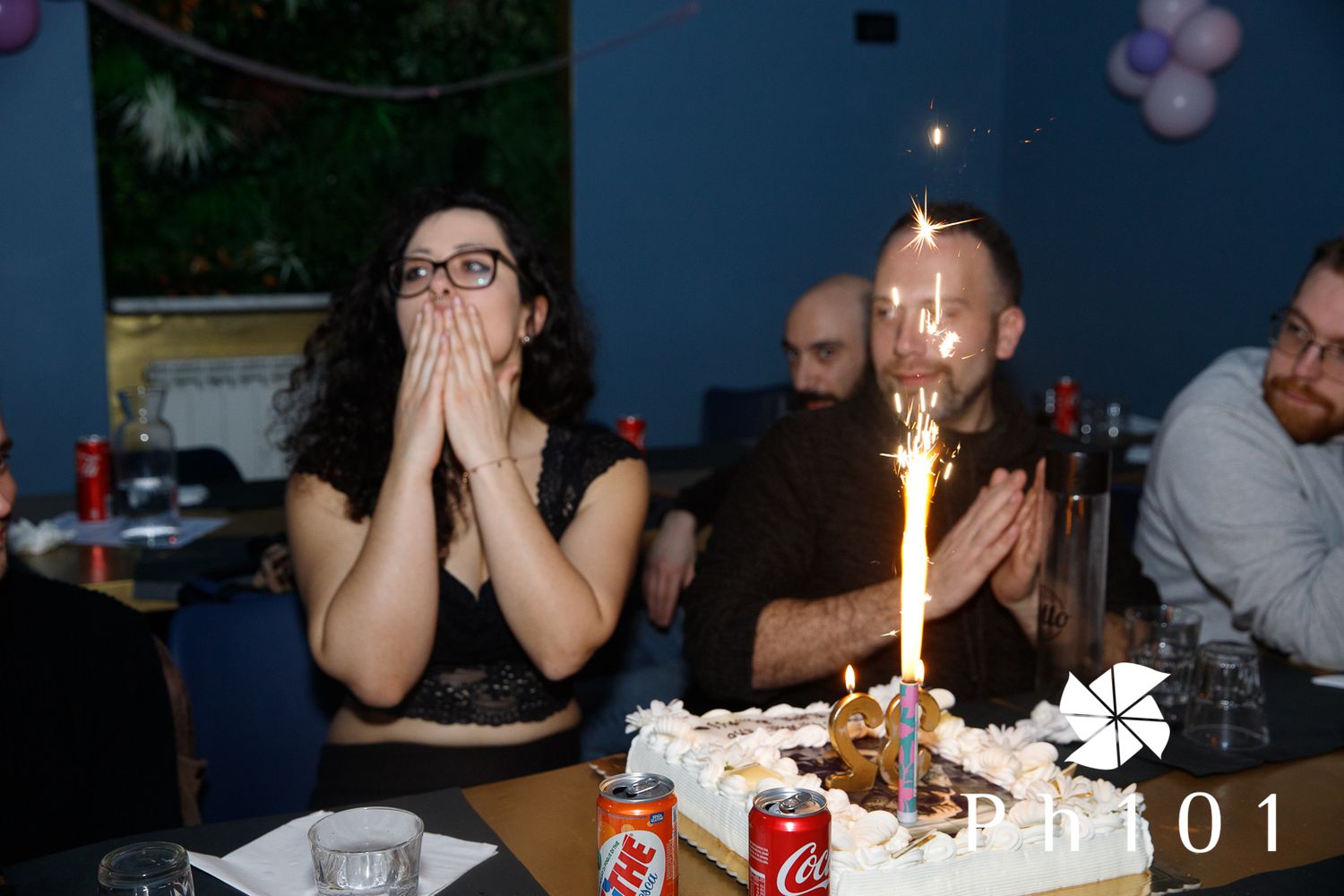 A celebration scene with lit candles and party decorations in a dimly lit room.