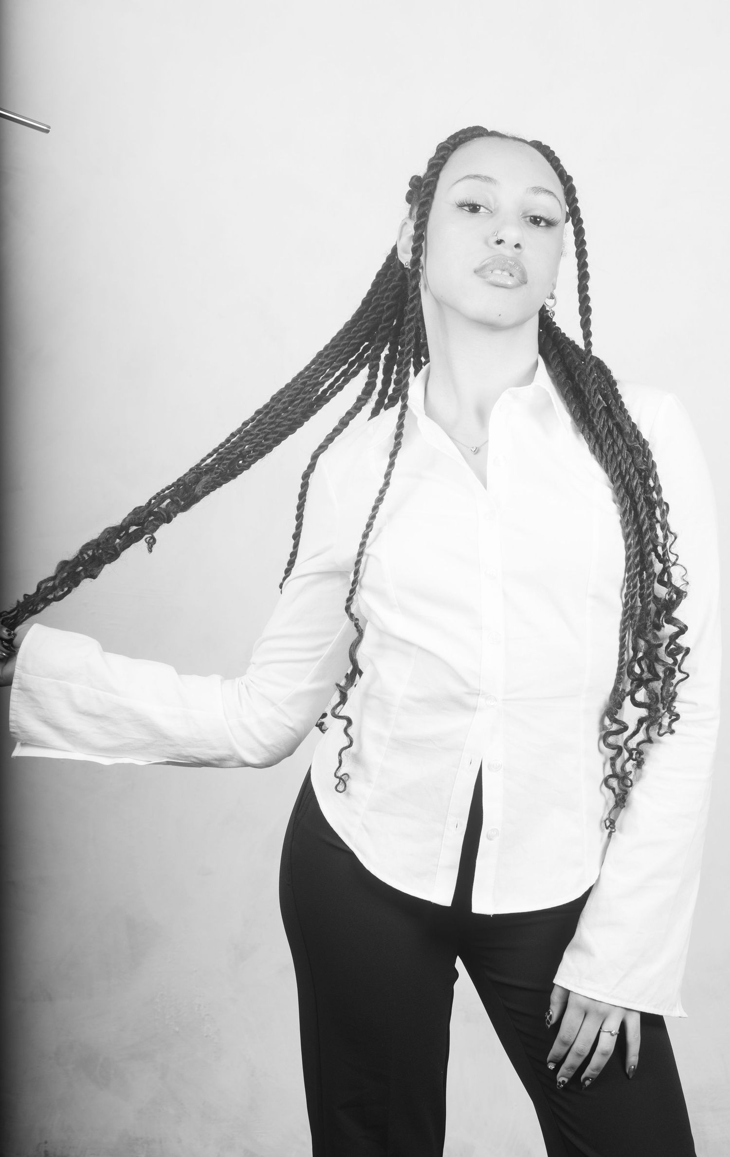 Black and white fashion portraits showing dynamic poses in white shirt and dark pants.