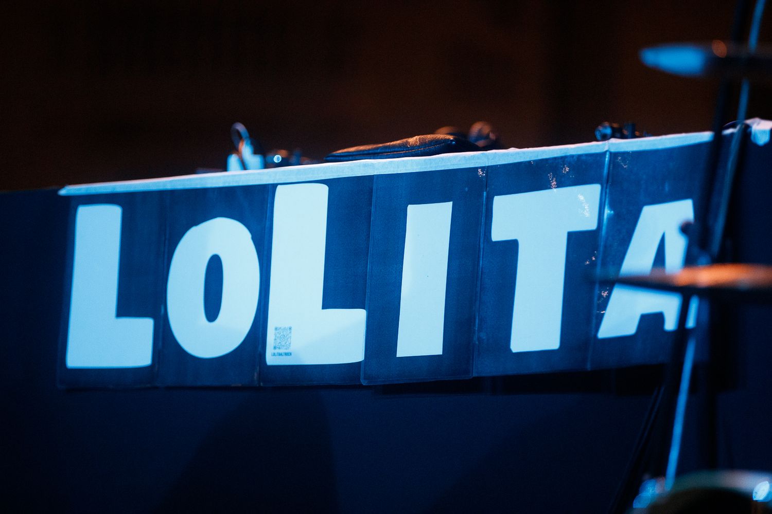 Illuminated blue text sign spelling 'LOLITA' against a dark background.