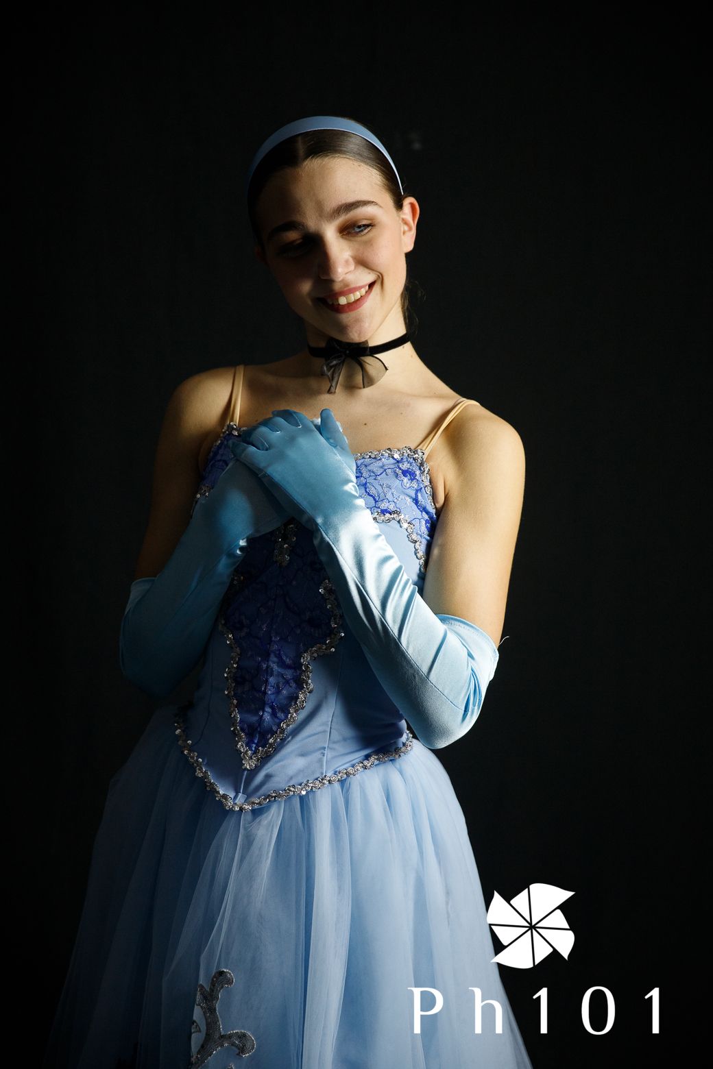 Elegant light blue ballgown with sequin details photographed against dark background.