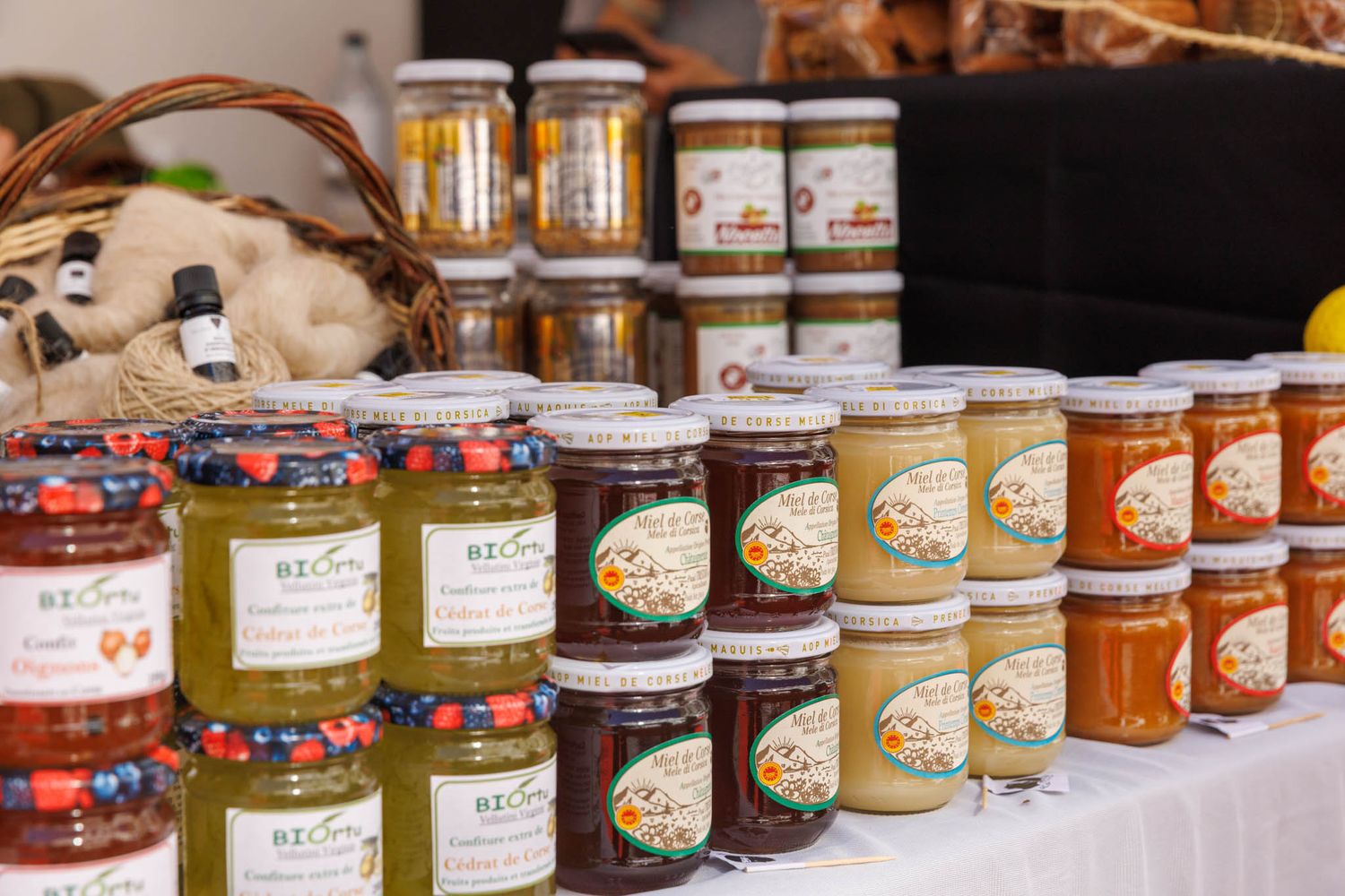 Long display of various jars containing preserves and spreads arranged in a row.
