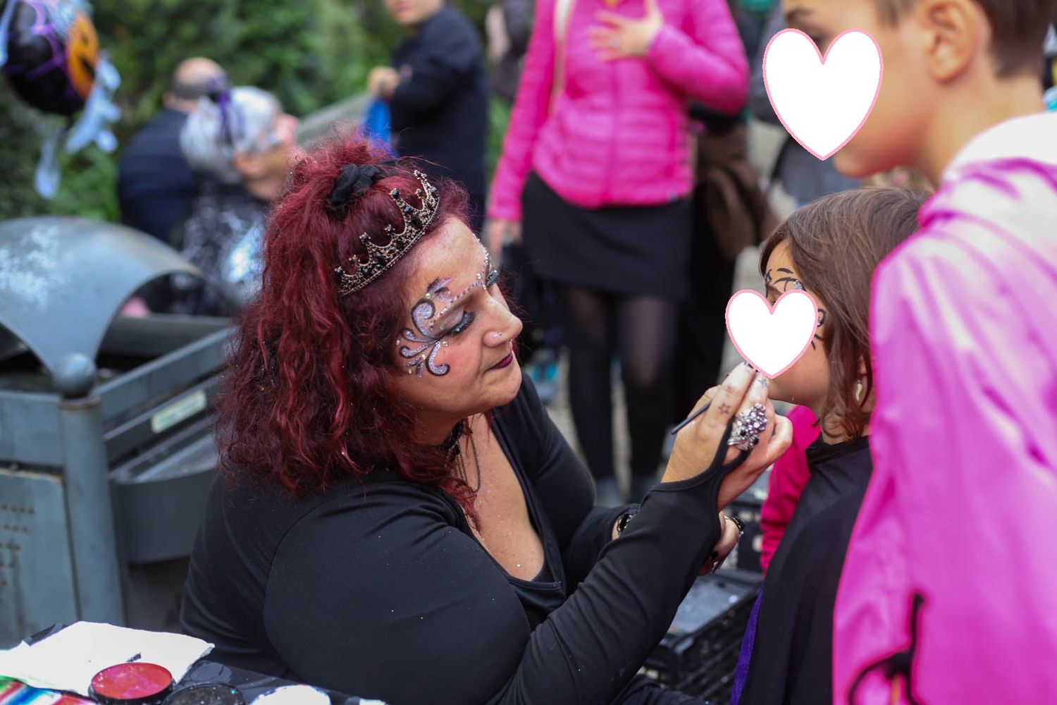 People celebrating at an outdoor Halloween event with bright pink clothing and costumes.