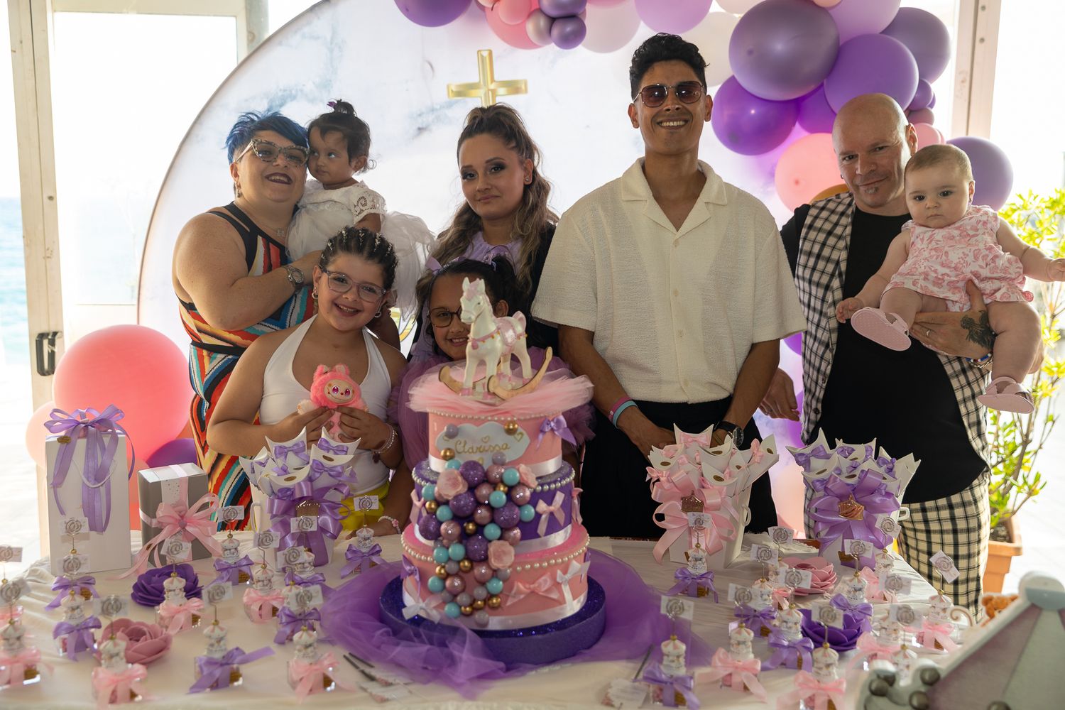 Birthday celebration with purple and pink decorated cake and balloons.