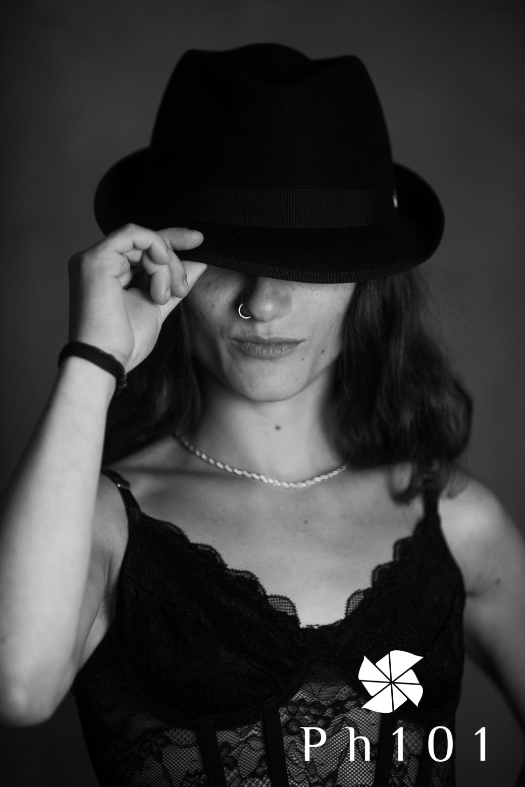 Dramatic black and white portrait series featuring black lace and hat accessories.