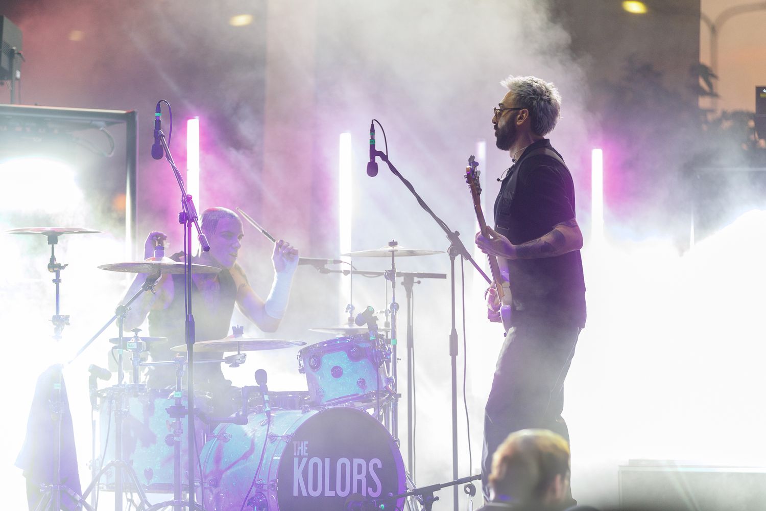Concert stage filled with atmospheric fog and purple lighting effects.